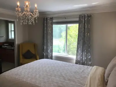 a bedroom with a bed and a window with a chandelier at Royalty B&B in Richmond