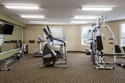 a gym with tread machines and a flat screen tv at Super 8 by Wyndham Sherwood Park/Edmonton Area in Sherwood Park