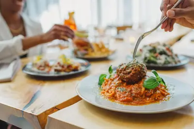 a group of people sitting at a table with plates of food at JW Marriott Edmonton ICE District in Edmonton