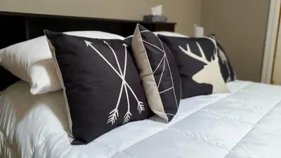 a bed with black and white pillows on it at Kimberley Downtown Accommodation in Kimberley
