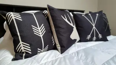 a bed with black and white pillows on it at Kimberley Downtown Accommodation in Kimberley