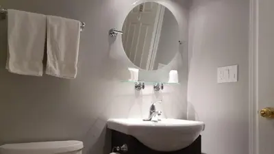 a white bathroom with a sink and a mirror at Kimberley Downtown Accommodation in Kimberley