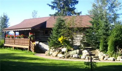a cabin with a bunch of rocks in front of it at Nakiska Bear Ranch in Clearwater