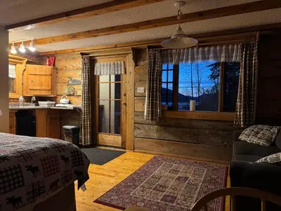 a bedroom with a bed and a kitchen with a window at Nakiska Bear Ranch in Clearwater