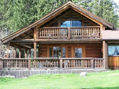 a large wooden cabin with a large balcony at Nakiska Bear Ranch in Clearwater
