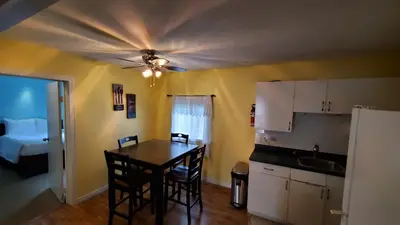 a kitchen with a table and a ceiling fan at Comox Valley Inn & Suites in Courtenay