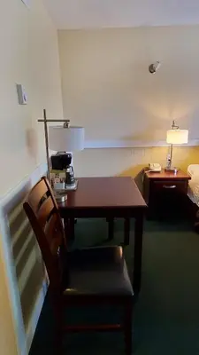 a table and a chair in a hotel room at Comox Valley Inn & Suites in Courtenay