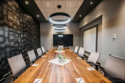 a conference room with a long wooden table and chairs at The Explorer Hotel in Yellowknife