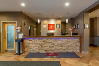 a lobby of a hotel with a bar in the middle at Devonian Hotel and Suites in Fox Creek