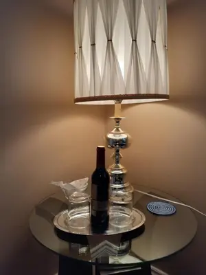 a bottle of wine on a glass table with a lamp at Rae Leigh Heights BnB in Saanichton