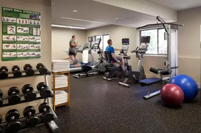 two men working out in a gym with weights at Holiday Inn & Suites Vancouver Downtown by IHG in Vancouver
