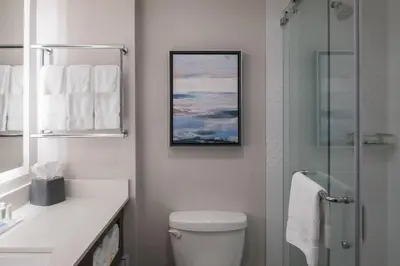 a bathroom with a toilet and a glass shower at Holiday Inn & Suites Vancouver Downtown by IHG in Vancouver