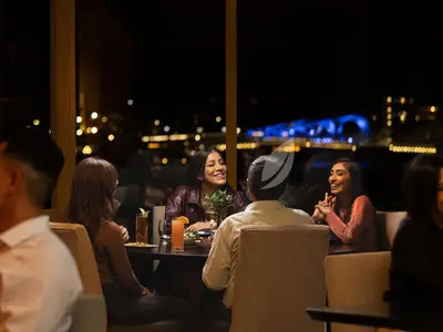 a group of people sitting at a table in a restaurant at Inn at Laurel Point in Victoria