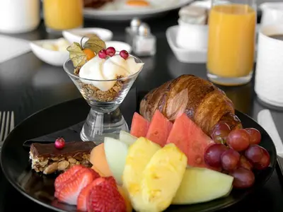 a plate of food with fruit on a table at Inn at Laurel Point in Victoria