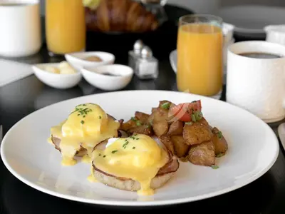 a plate of food with eggs and potatoes on a table at Inn at Laurel Point in Victoria