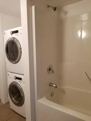 a bathroom with a washing machine next to a shower at Chateau Riverside in Campbell River