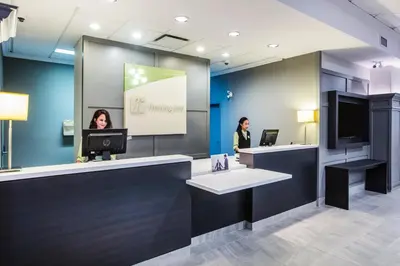 two women standing at a counter in a dental office at Holiday Inn & Suites Grande Prairie by IHG in Grande Prairie