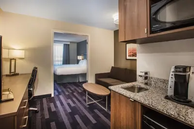 a small kitchen and living room in a hotel room at Holiday Inn & Suites Grande Prairie by IHG in Grande Prairie