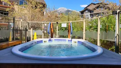 a hot tub in the middle of a patio at ⭐️ Luxury Mountain View Studio in Canmore ⭐️ in Canmore