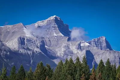 a mountain with trees in front of it at ⭐️ Luxury Mountain View Studio in Canmore ⭐️ in Canmore