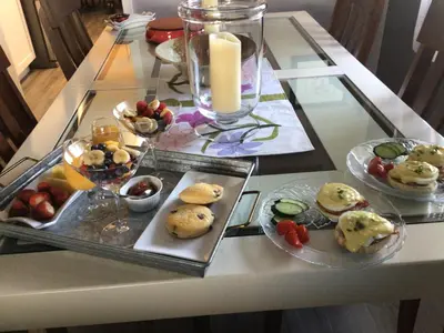 a glass table with plates of food on it at Berkie’s Bed & Breakfast in Port Alberni