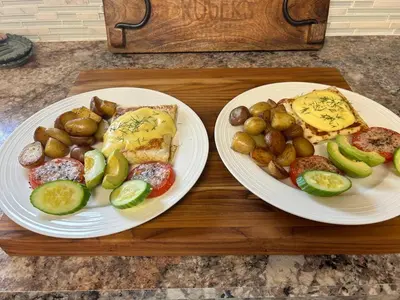 two plates of food with potatoes and vegetables on a table at Berkie’s Bed & Breakfast in Port Alberni