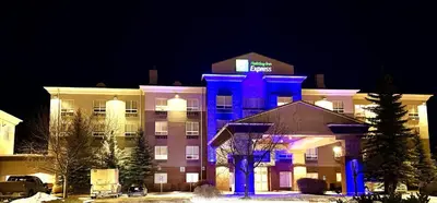 a hotel with a blue lighted building at night at Holiday Inn Express Airdrie by IHG in Airdrie
