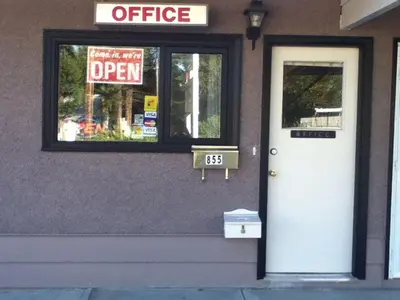 a door to a coffee shop with a sign in a window at Gold Pan Motel in Quesnel