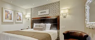 a hotel room with a bed and a chair at Helm's Inn in Victoria