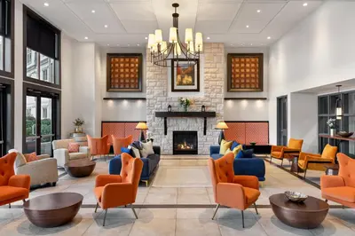 a lobby with orange chairs and a fireplace at Walnut Beach Resort in Osoyoos