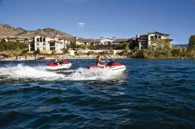 two people are riding on boats in the water at Walnut Beach Resort in Osoyoos