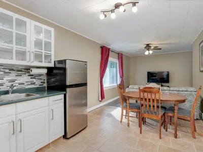 a kitchen and dining room with a table and refrigerator at Malahat Bungalows Motel in Malahat
