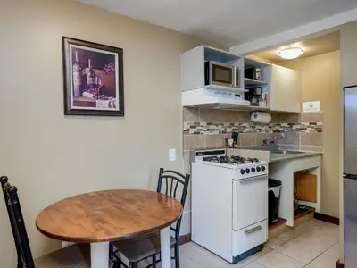a small kitchen with a table and a white stove at Malahat Bungalows Motel in Malahat