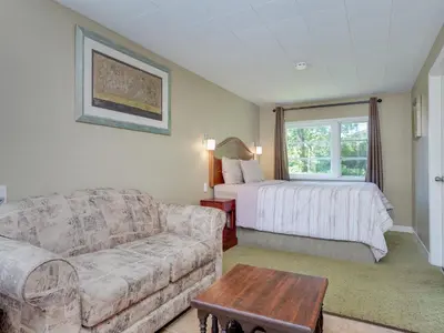a living room with a couch and a bed at Malahat Bungalows Motel in Malahat