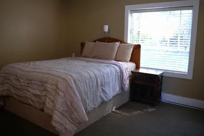 a bedroom with a large bed and a window at Malahat Bungalows Motel in Malahat