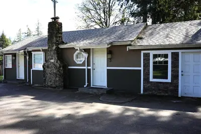 a small house with a chimney and a garage at Malahat Bungalows Motel in Malahat