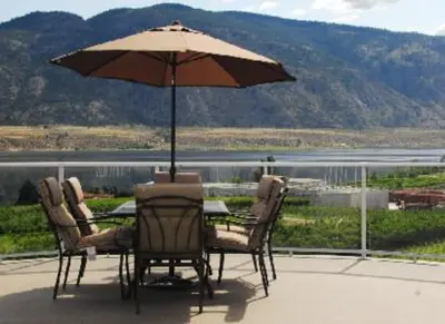 a table and chairs with an umbrella on a patio at Ciliegia Villa in Osoyoos