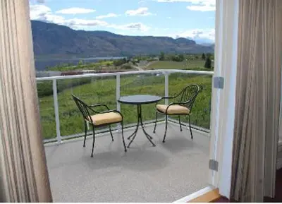 a balcony with a table and chairs and a view at Ciliegia Villa in Osoyoos