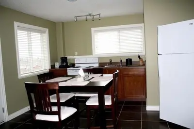 a kitchen with a table and chairs and a refrigerator at Ciliegia Villa in Osoyoos