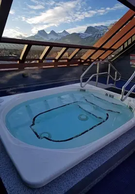 a jacuzzi tub on a balcony with mountains at Downtown Loft, Mountain Views, Fireplace, Couple's Retreat, Walker's Paradise in Canmore