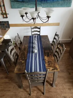 a wooden table with chairs around it with a blue napkin on it at Downtown Loft, Mountain Views, Fireplace, Couple's Retreat, Walker's Paradise in Canmore