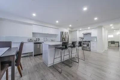 a kitchen with white cabinets and a table and chairs at Private Vacation Guest Suite Near Beach in White Rock