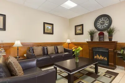 a living room with couches and a fireplace at Days Inn by Wyndham Chetwynd in Chetwynd