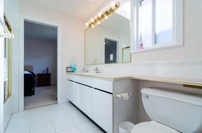 a bathroom with a toilet and a sink and a mirror at 3 Private, spacious, bright rooms in a Gorgeous house in New Westminster