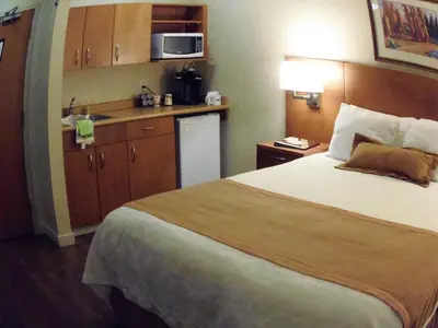 a hotel room with a bed and a sink at Rosslyn Inn & Suites in Edmonton