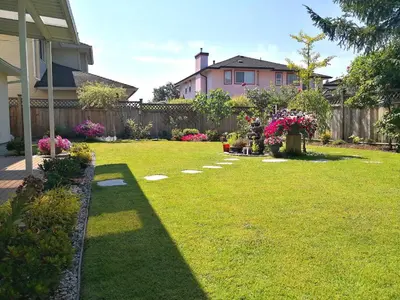 a yard with a fence and a garden with flowers at Great Guest Suite in a Gorgeous House in New Westminster