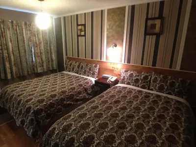 a hotel room with two beds and two lamps at Galaxy Motel in St. Paul