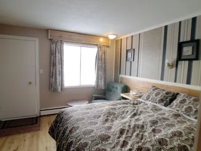 a hotel room with a bed and a window at Galaxy Motel in St. Paul