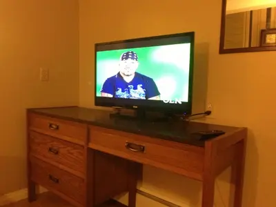 a flat screen tv sitting on top of a wooden dresser at Galaxy Motel in St. Paul