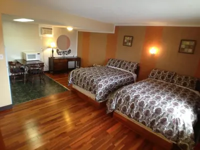 a hotel room with two beds and a table at Galaxy Motel in St. Paul